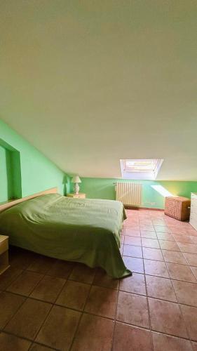 a green bedroom with a bed and a skylight at IL PICCOLO PARADISO in San Massimo