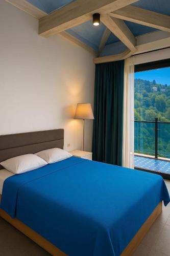 a bedroom with a blue bed and a large window at Panoramic Sea Apartment in Kvariati