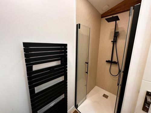 a shower in a bathroom with a glass shower stall at White housse - cabane - Sèvre Niortaise in Niort