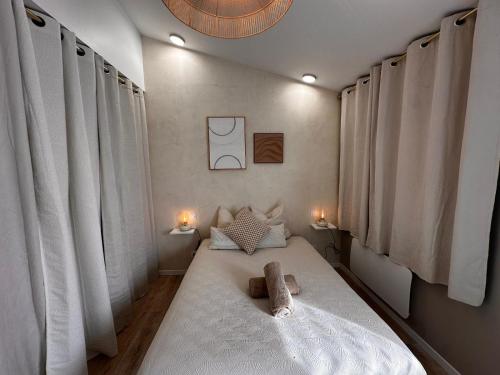a bedroom with a bed with two stuffed animals on it at White housse - cabane - Sèvre Niortaise in Niort