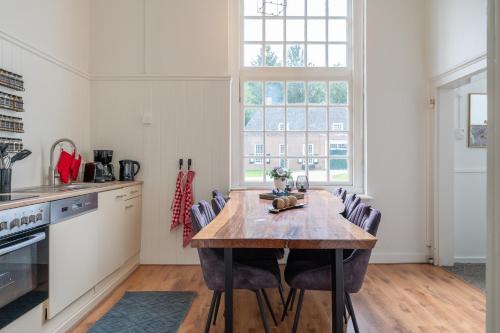 a kitchen with a wooden table and chairs at Zwaluwenburg 4 in 't Harde