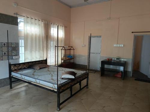a bedroom with a bed and a table in a room at Ira's Abode in Dibrugarh