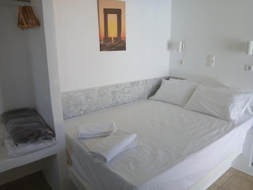 a bed with white sheets and pillows in a room at Studio Angelika in Glinado Naxos