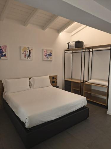 a bedroom with a large white bed and shelves at La Dimora dei Paladini in Bagheria
