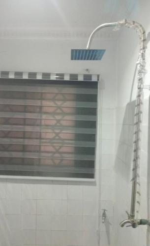 a shower in a bathroom with a window at Monarch Apartment in Oshogbo