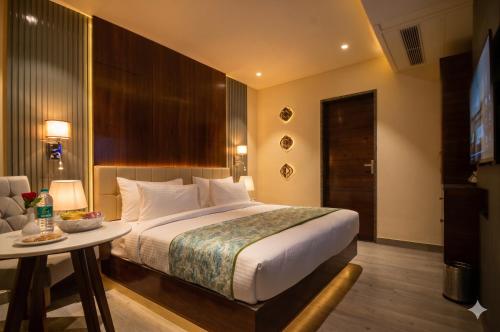 a hotel room with a bed and a table and a television at Hotel Everland Wish in Jaipur
