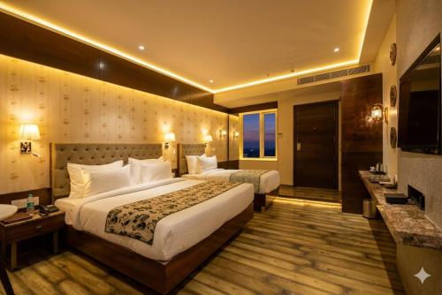 a hotel room with two beds and a bathroom at Hotel Everland Wish in Jaipur