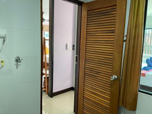 a bathroom with a wooden door and a shower at Smile Home in Patong Beach