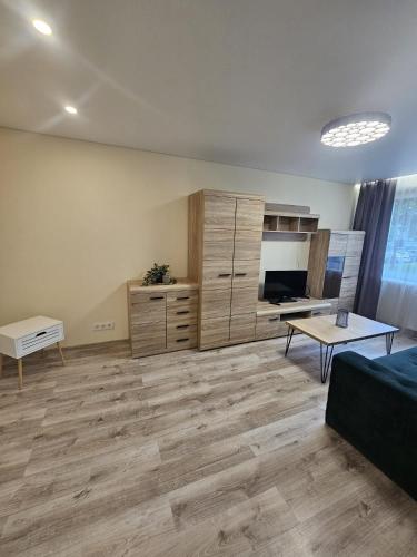 a large living room with a couch and a table at Taikos apartamentai in Utena