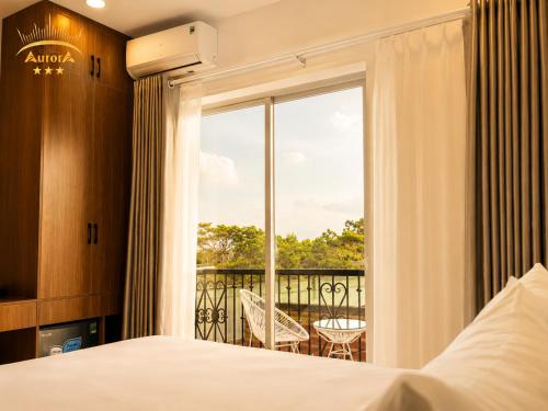 a hotel room with a bed and a balcony at Aurora Hotel Măng Đen in Kon Von Kla
