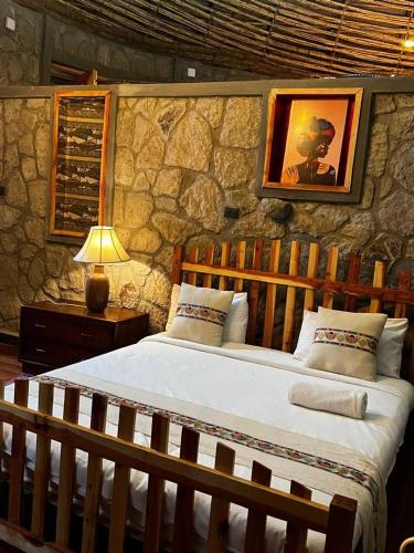 a bedroom with a large bed in a stone wall at Belema Resort & Spa in Jemo