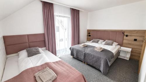 a hotel room with two beds and a window at Villa Fala in Dziwnówek