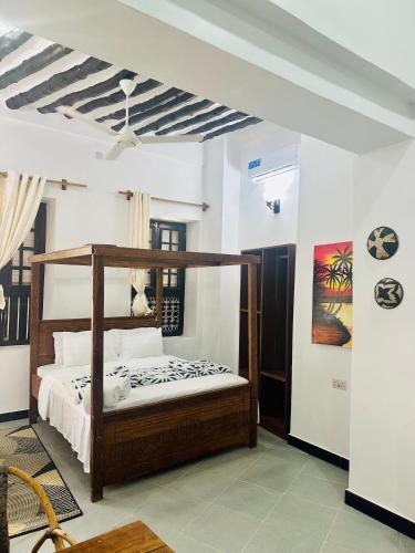 a bedroom with a wooden bed in a room at NorArt House in Zanzibar City