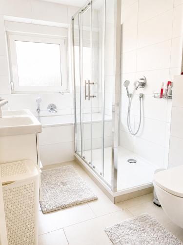 a white bathroom with a shower and a sink at Nürnberg Central Flat in Nuremberg
