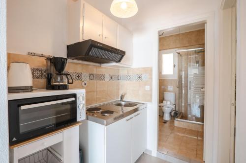 a small kitchen with a sink and a stove at Corfu Dream Holidays Villas Standarts in Glyfada