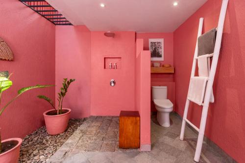 a pink bathroom with a toilet and a ladder at PinkCoco Gili Trawangan - Constant Surprises - for Cool Adults Only in Gili Trawangan