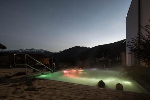 a swimming pool with lights in front of a building at Hotel Weisses Kreuz in Malles Venosta