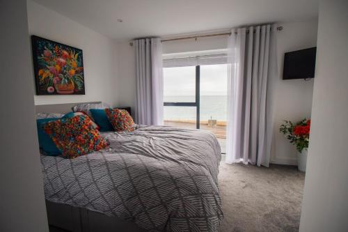 a bedroom with a bed with a view of the ocean at Marine View Apartment by Air Premier in Seaford