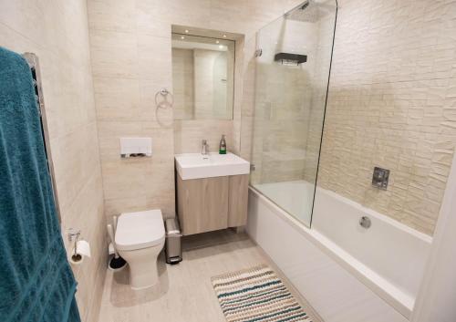 a bathroom with a toilet and a sink and a shower at Marine View Apartment by Air Premier in Seaford