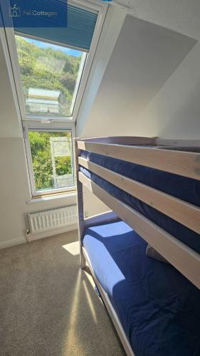 a bedroom with a bunk bed and a window at Driftwood in Porthtowan