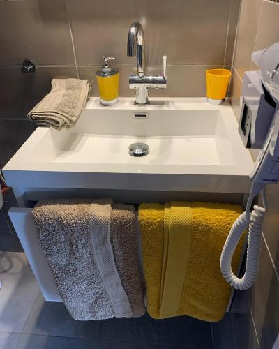 a bathroom sink with towels hanging under it at Chez BIBI in Grand-Bourg