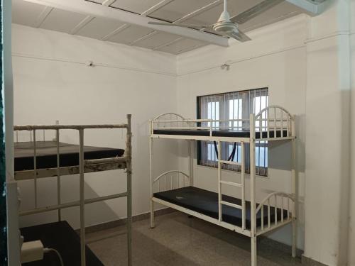 two bunk beds in a room with a ceiling at White House KMCT in Kapūrwāhāl