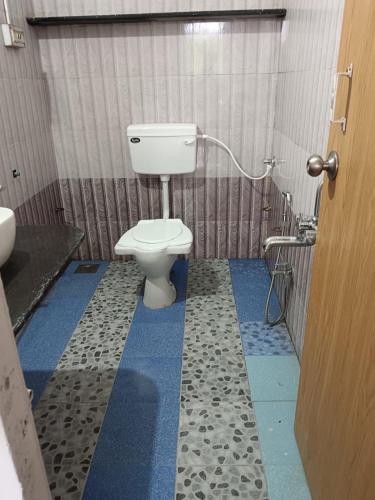 a bathroom with a toilet and a blue floor at White House KMCT in Kapūrwāhāl