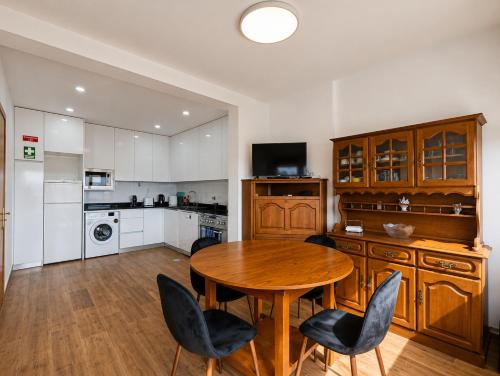 a kitchen with a wooden table and chairs at Casa Machado in Vila Real