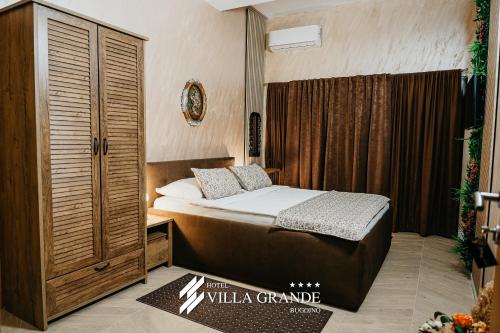 a bedroom with a bed and a wooden cabinet at Villa Grande Terrace Jacuzzi Suite in Bugojno