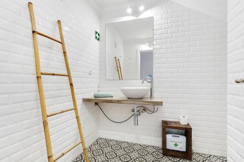a white bathroom with a sink and a mirror at AnchorHouse Portugal in Aljezur