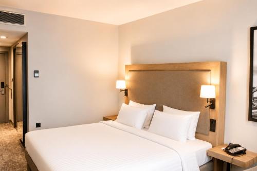 a bedroom with a large white bed with two lamps at Radisson Blu Hotel, Liverpool in Liverpool