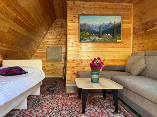 a room with a bed and a couch and a table at Bayaman Guest House in Bokonbayevo