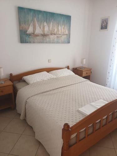 a bedroom with a large bed with a painting on the wall at Apartments Jurkovic in Grebaštica