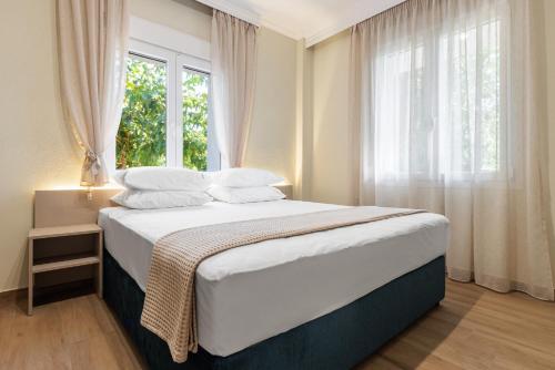 a bedroom with a large bed with a window at KYMA STAY - Beachfront apartments in Pálioura