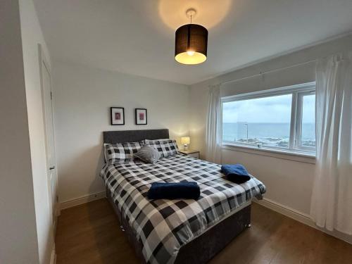 a bedroom with a bed and a large window at Carley's House - Macduff Seaside Escape in Macduff