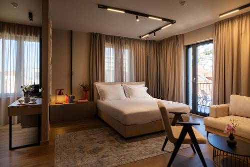 a bedroom with a bed and a couch and a chair at Hotel Aquarius Dubrovnik in Dubrovnik