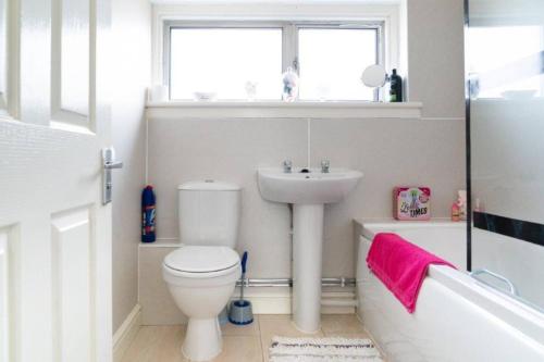 a bathroom with a toilet and a sink and a window at Carley's House - Macduff Seaside Escape in Macduff