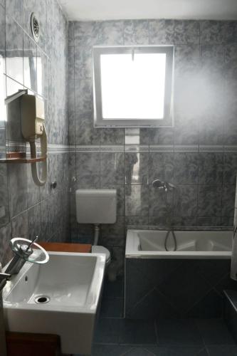 a bathroom with a sink and a tub and a toilet at Holiday house Ogi in Bar