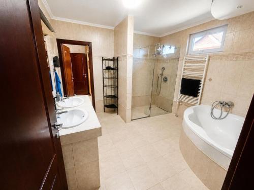 a bathroom with two sinks and a tub and a shower at 21 Star Residence in Darnózseli