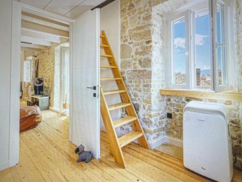 a room with a stone wall and a wooden staircase at Amazing apartment with view in Kanoni