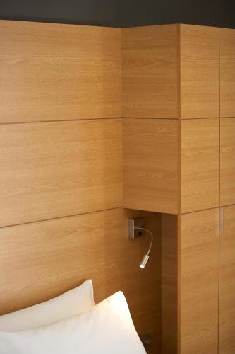 a headboard of a bed with a wooden wall at Aegli Hotel Volos in Volos