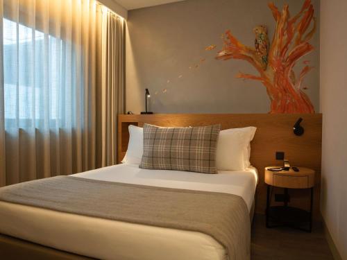 a bedroom with a large bed and a window at ibis Styles Lisboa Aeroporto in Lisbon