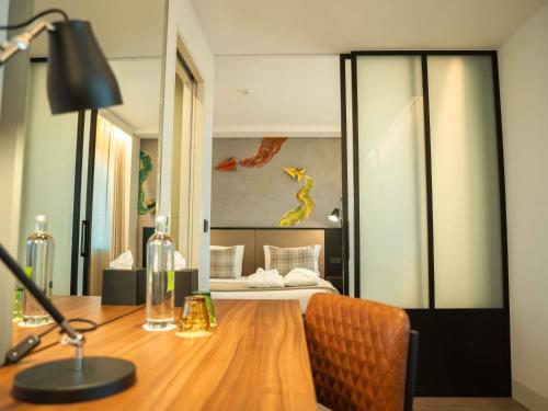 a room with a desk with a bed in the background at ibis Styles Lisboa Aeroporto in Lisbon