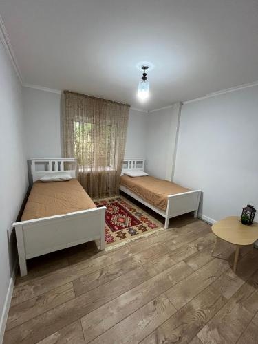 a bedroom with two beds and a table at Burabay Lake Walk House in Borovoye