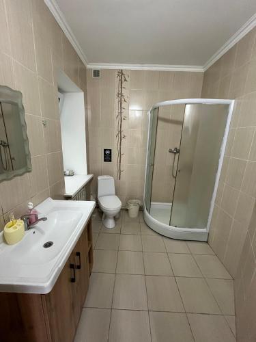 a bathroom with a shower and a toilet and a sink at Burabay Lake Walk House in Borovoye