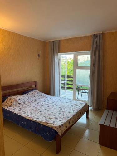 a bedroom with a bed and a sliding glass door at Миндаль in Zatoka