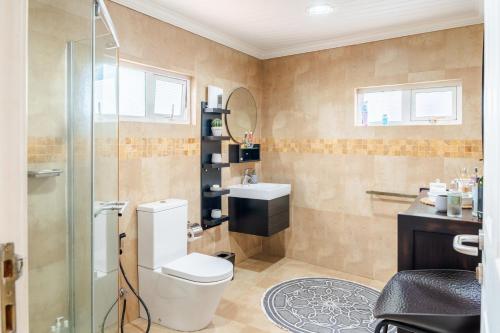 a bathroom with a toilet and a sink at Luxe Oasis Palma in Quatre Bornes