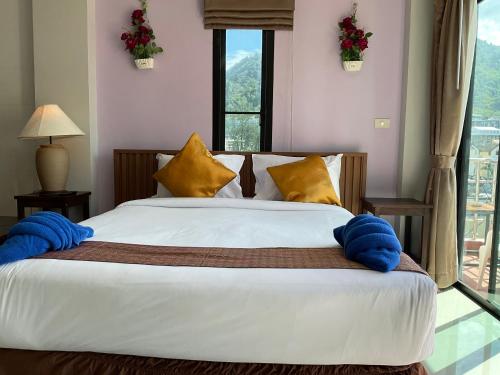 a bedroom with a bed with yellow and blue pillows at Smile Home in Patong Beach