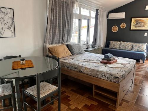 a room with a bed and a table and a couch at Sofita garden in Nea Michaniona