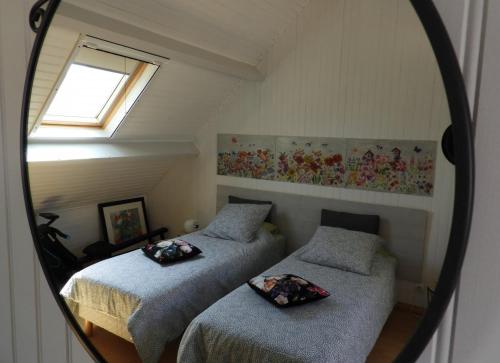 two beds in a room with a mirror at Au Pré Fleury in Fleury-en-Bière